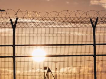 Prison fence in front of gold sunset